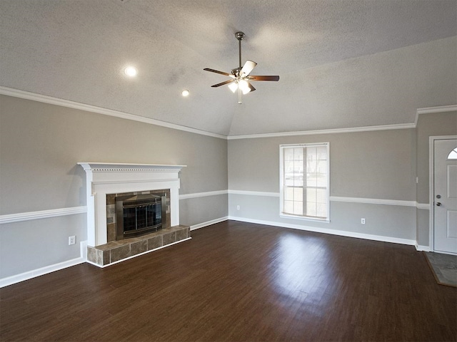 unfurnished living room with a ceiling fan, vaulted ceiling, a textured ceiling, wood finished floors, and a tiled fireplace