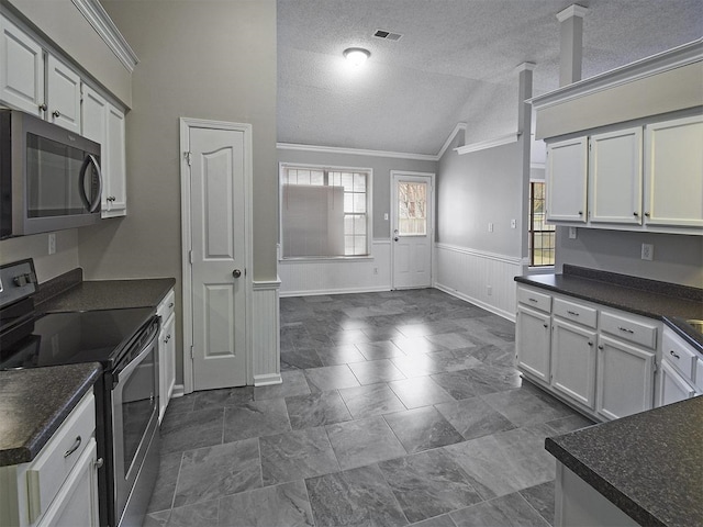 kitchen with stainless steel electric range oven, lofted ceiling, crown molding, dark countertops, and a textured ceiling