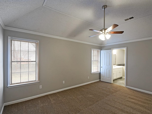 unfurnished bedroom with crown molding, carpet, baseboards, a textured ceiling, and connected bathroom