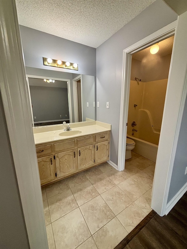 full bath featuring toilet, vanity, bathing tub / shower combination, a textured ceiling, and tile patterned flooring