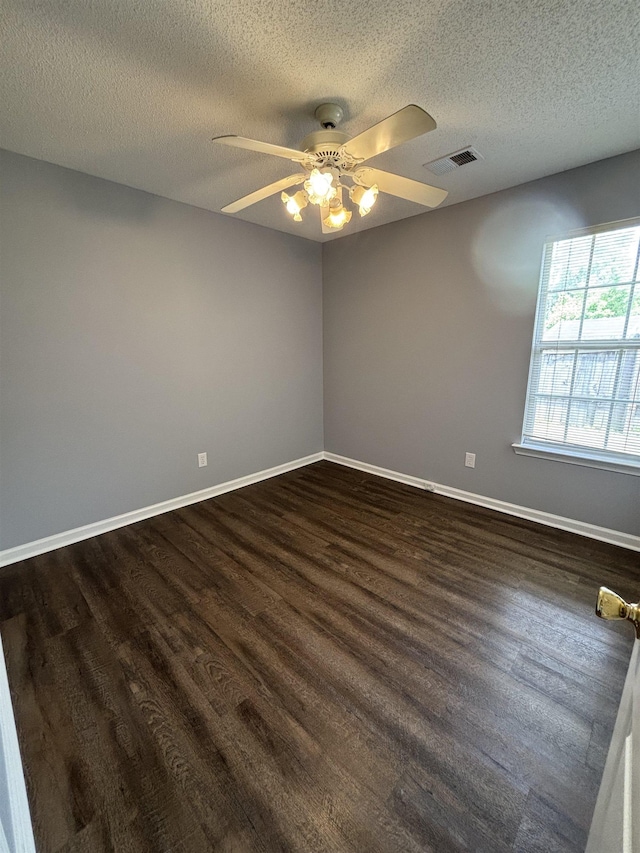 unfurnished room featuring dark wood-style flooring, ceiling fan, a textured ceiling, and baseboards