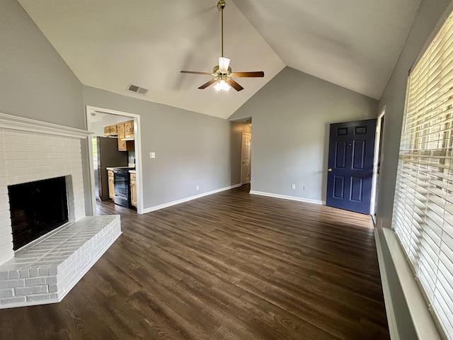 unfurnished living room featuring lofted ceiling, ceiling fan, dark wood finished floors, a fireplace, and baseboards