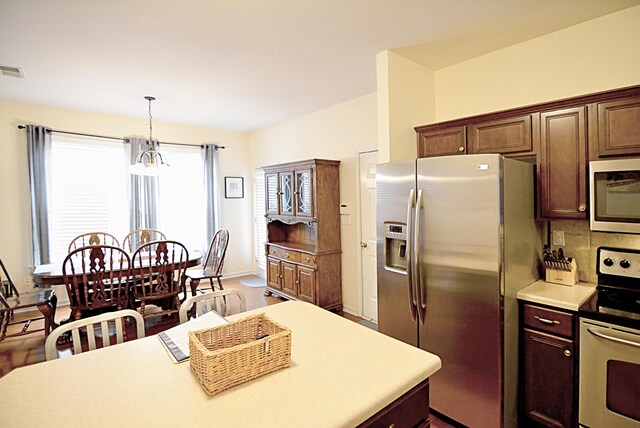 1342 Harbor Park Dr, Memphis, TN 38103 - kitchen featuring appliances with stainless steel finishes, a chandelier, light countertops, hanging light fixtures, and baseboards