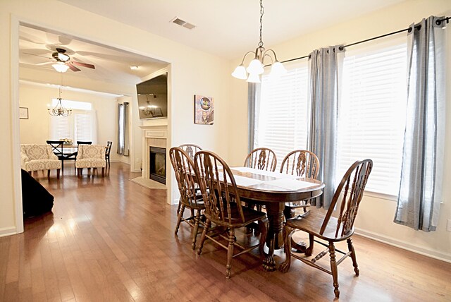 1342 Harbor Park Dr, Memphis, TN 38103 - dining room with a chandelier, light wood-style floors, a fireplace with flush hearth, and baseboards