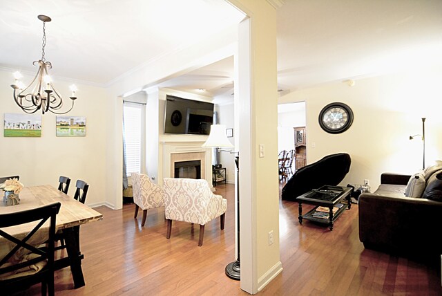 1342 Harbor Park Dr, Memphis, TN 38103 - living room with a chandelier, wood finished floors, a glass covered fireplace, and ornamental molding