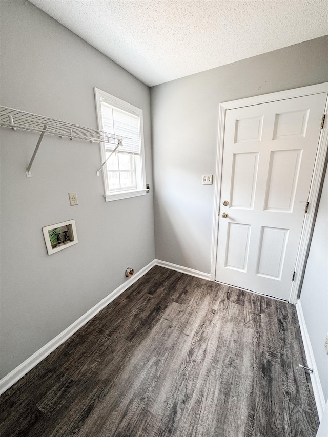 washroom featuring dark wood-type flooring, washer hookup, a textured ceiling, and baseboards