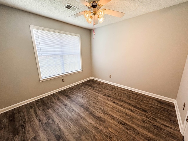 spare room featuring dark wood-style flooring, ceiling fan, baseboards, and a textured ceiling