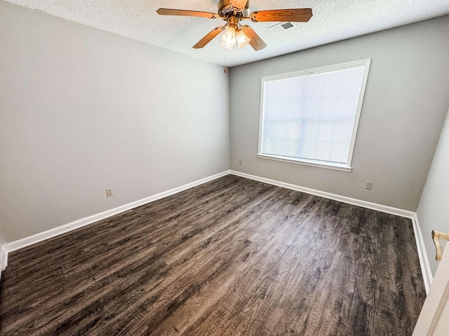 spare room featuring dark wood-style floors, a textured ceiling, baseboards, and ceiling fan