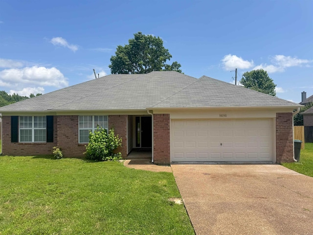 single story home with driveway, a front yard, an attached garage, and brick siding