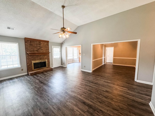 unfurnished living room featuring baseboards, ceiling fan, dark wood-type flooring, a textured ceiling, and high vaulted ceiling