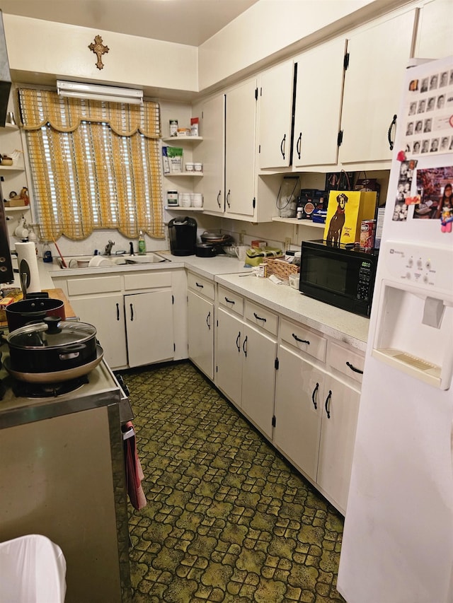 1993 Higbee Ave, Memphis, TN 38104 - kitchen with black microwave, open shelves, light countertops, white cabinets, and a sink
