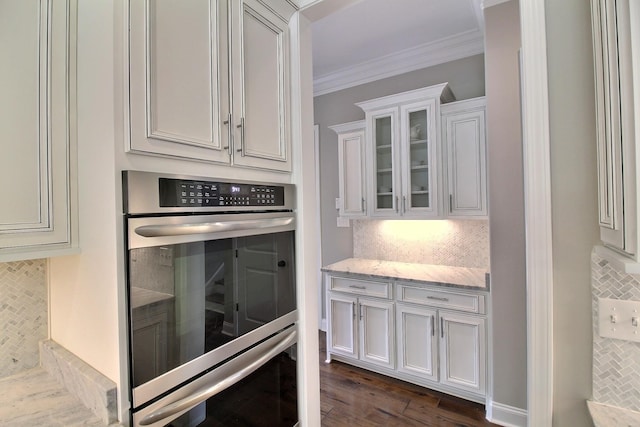 75 Windgrove Cv, Piperton, TN 38017 - kitchen featuring stainless steel double oven, decorative backsplash, ornamental molding, light stone countertops, and glass insert cabinets