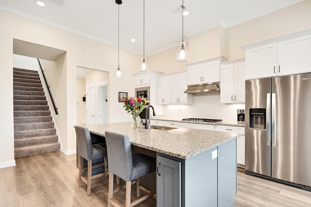 6423 Osier Cv, Bartlett, TN 38135 - kitchen with stainless steel appliances, a sink, under cabinet range hood, backsplash, and white cabinetry
