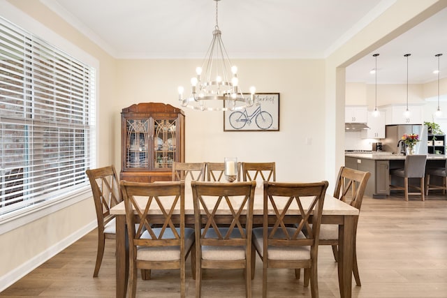 6423 Osier Cv, Bartlett, TN 38135 - dining area featuring a chandelier, light wood-style flooring, crown molding, and baseboards
