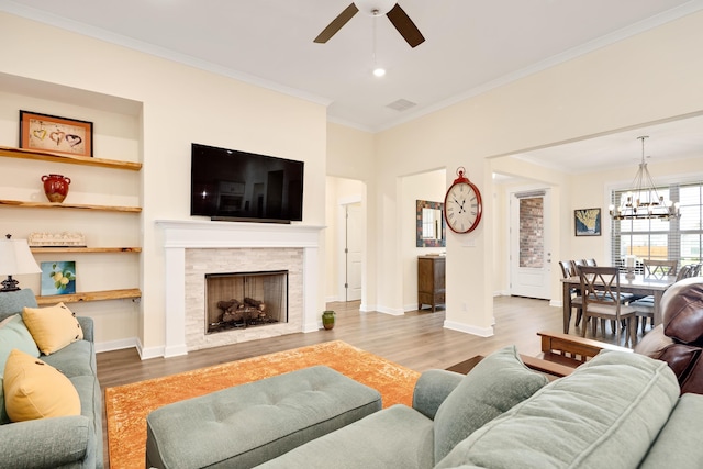 6423 Osier Cv, Bartlett, TN 38135 - living room with ornamental molding, wood finished floors, a ceiling fan, a chandelier, and a stone fireplace