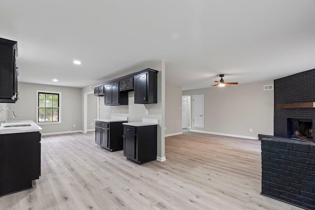 6410 Coteswood Rd, Memphis, TN 38134 - kitchen with a sink, light wood-type flooring, a ceiling fan, dark cabinetry, and recessed lighting