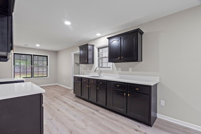 6410 Coteswood Rd, Memphis, TN 38134 - kitchen with light wood-style flooring, light countertops, a sink, baseboards, and recessed lighting