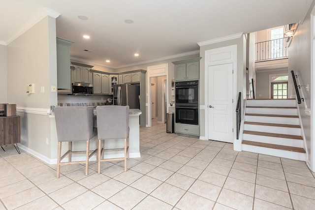 1796 Campden Dr, Collierville, TN 38017 - kitchen with stainless steel appliances, a peninsula, ornamental molding, gray cabinetry, and a kitchen breakfast bar