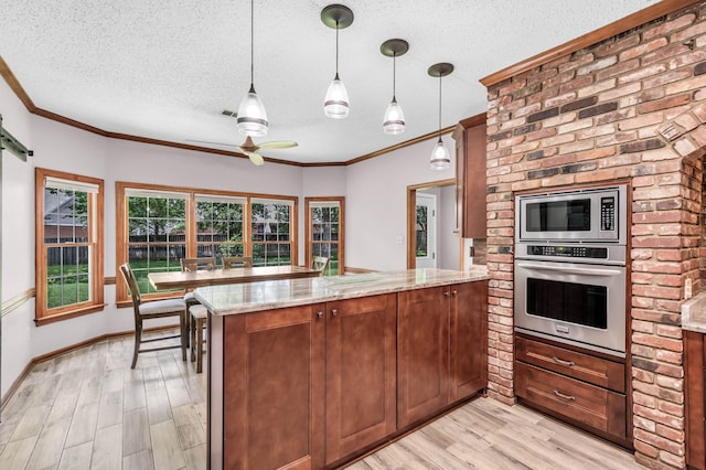 858 Gunnison Dr, Collierville, TN 38017 - kitchen with appliances with stainless steel finishes, a peninsula, a textured ceiling, light wood-type flooring, and light stone counters
