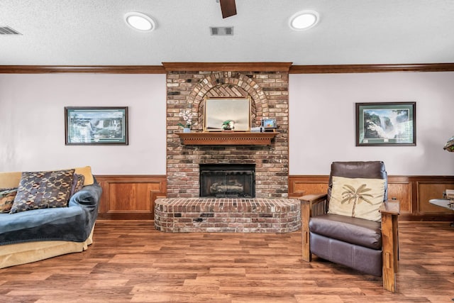 858 Gunnison Dr, Collierville, TN 38017 - living room featuring ornamental molding, a wainscoted wall, wood finished floors, a brick fireplace, and a textured ceiling