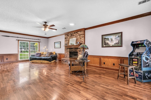 858 Gunnison Dr, Collierville, TN 38017 - living room with ornamental molding, ceiling fan, wood finished floors, a wainscoted wall, and a brick fireplace
