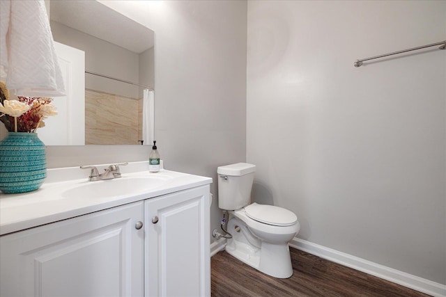full bath featuring wood finished floors, toilet, vanity, and baseboards