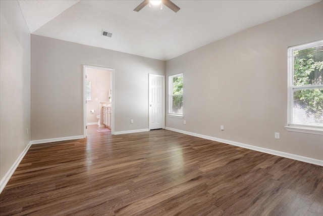 unfurnished room with a ceiling fan, vaulted ceiling, dark wood finished floors, and baseboards