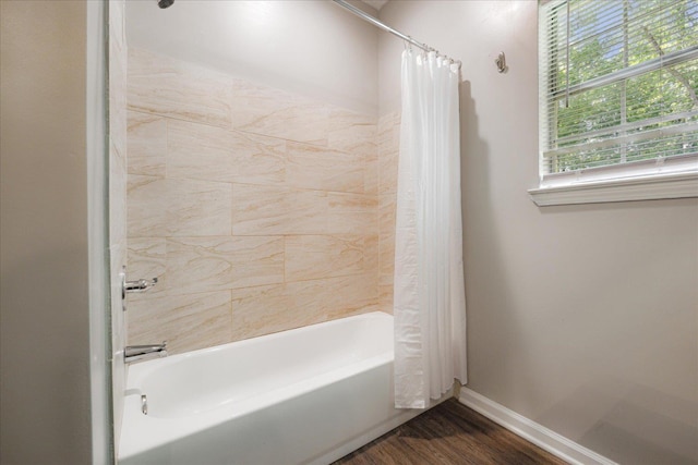 bathroom featuring shower / tub combo with curtain, baseboards, and wood finished floors