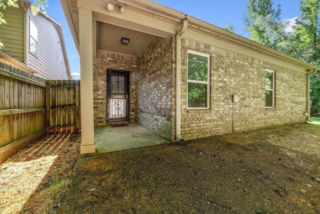 view of exterior entry featuring brick siding