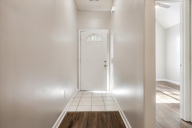 doorway to outside featuring baseboards and wood finished floors