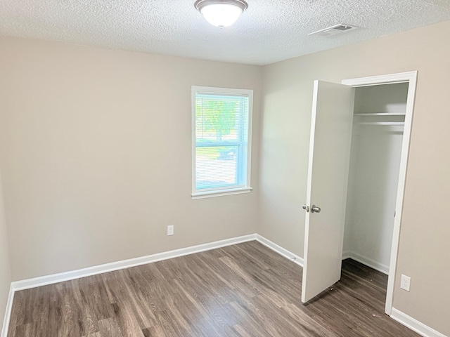 3170 Harvester Ln, Memphis, TN 38127 - unfurnished bedroom with wood finished floors, a textured ceiling, a closet, and baseboards
