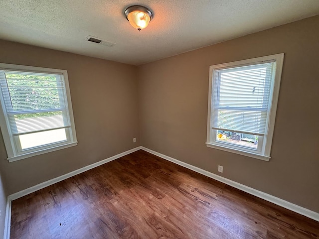 1591 Michael St, Memphis, TN 38111 - empty room featuring dark wood-style floors, plenty of natural light, baseboards, and a textured ceiling