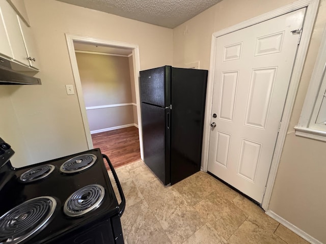 1591 Michael St, Memphis, TN 38111 - kitchen with black appliances, a textured ceiling, under cabinet range hood, white cabinets, and baseboards
