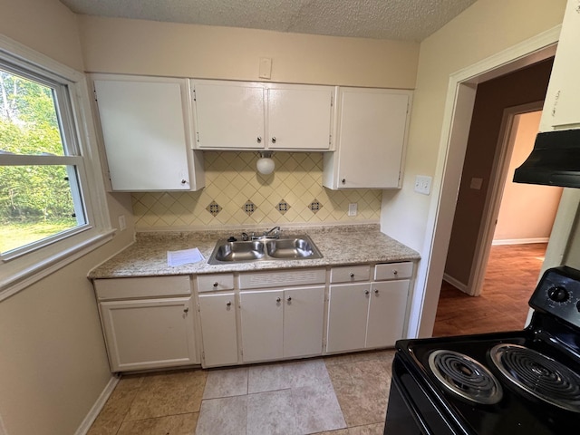 1591 Michael St, Memphis, TN 38111 - kitchen with black electric range oven, a sink, under cabinet range hood, light countertops, and a textured ceiling