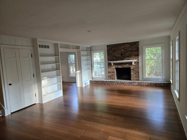 137 Perkins Ext, Memphis, TN 38117 - unfurnished living room featuring dark wood-style floors, built in shelves, ornamental molding, and a fireplace