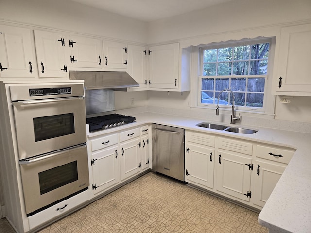 137 Perkins Ext, Memphis, TN 38117 - kitchen with stainless steel appliances, a sink, under cabinet range hood, light countertops, and white cabinetry