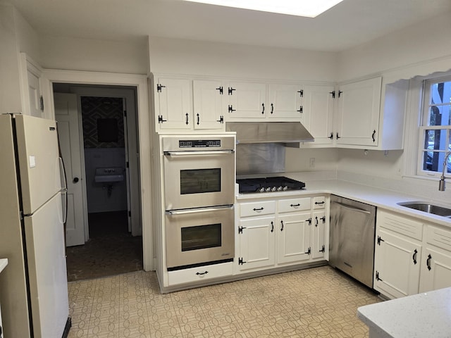137 Perkins Ext, Memphis, TN 38117 - kitchen with stainless steel appliances, under cabinet range hood, a sink, light countertops, and white cabinets
