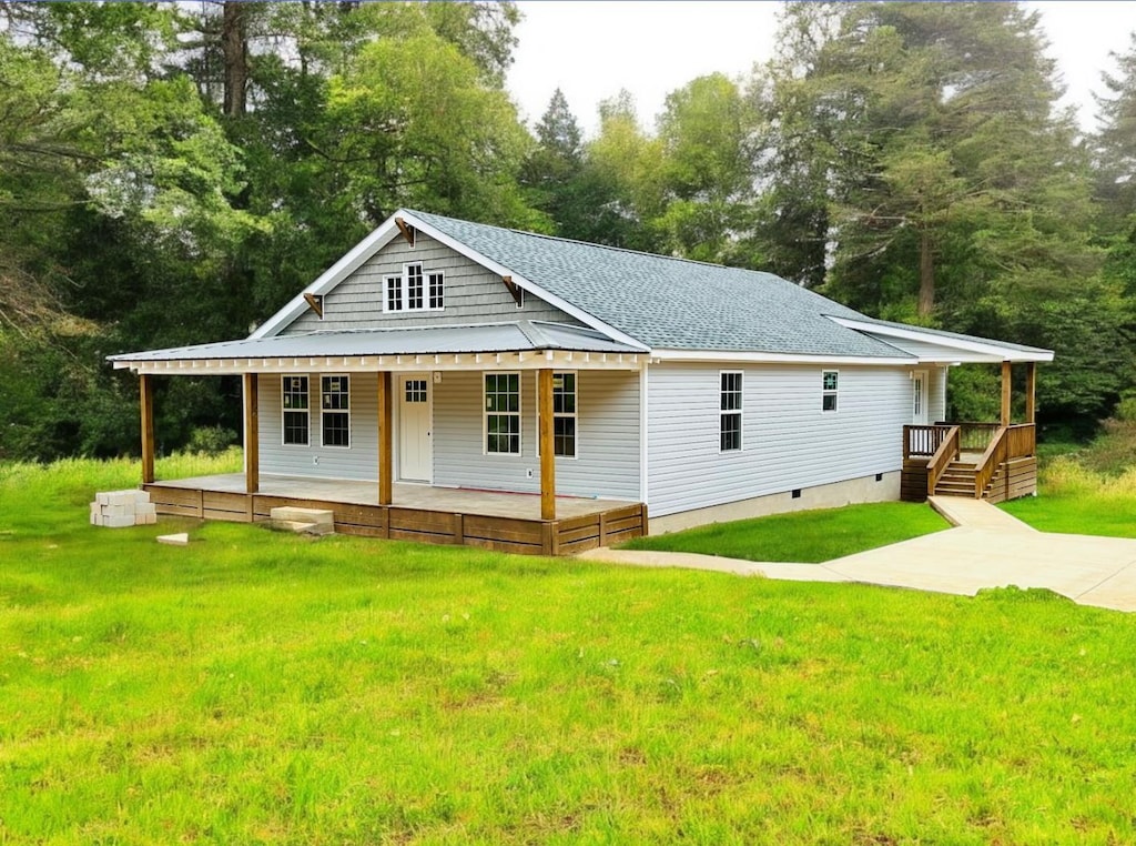 5184 Ramer Selmer Rd, Selmer, TN 38375 - view of front facade featuring covered porch, a front lawn, view of wooded area, and a shingled roof
