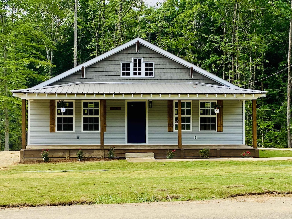 5184 Ramer Selmer Rd, Selmer, TN 38375 - view of front of property with a porch, a front yard, and metal roof