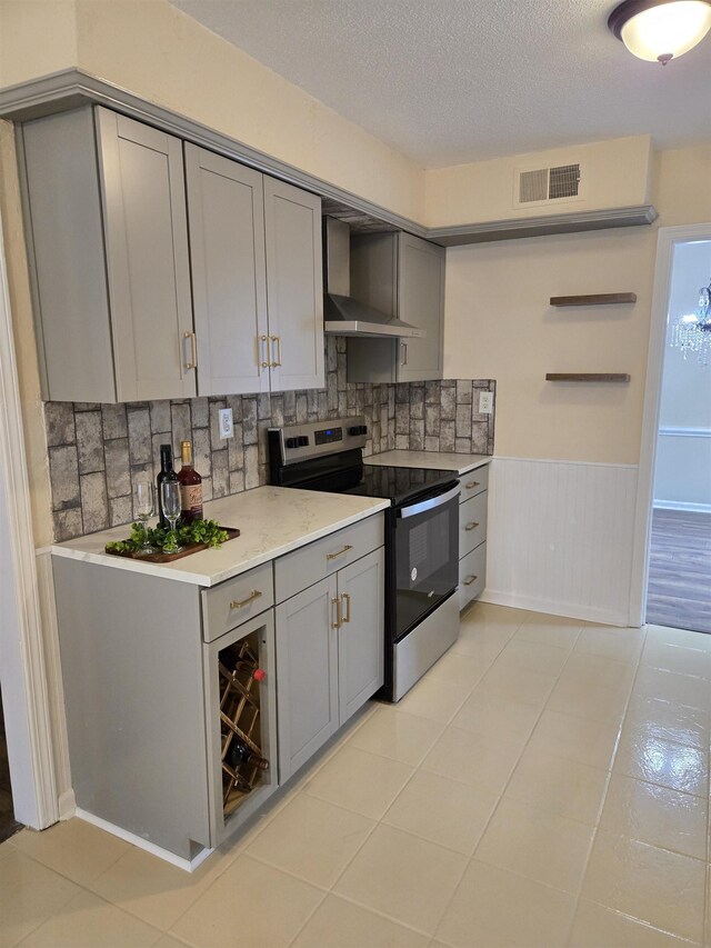 3403 Lynchburg St, Memphis, TN 38134 - kitchen with electric stove, gray cabinetry, wall chimney exhaust hood, decorative backsplash, and light countertops