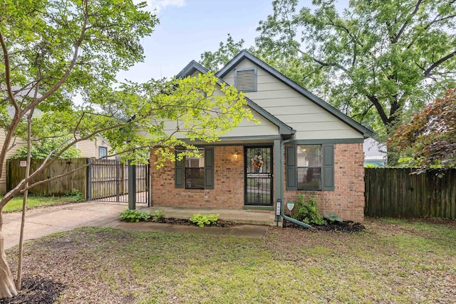 1000 S Cox St, Memphis, TN 38104 - bungalow-style home with brick siding, a gate, concrete driveway, and covered porch
