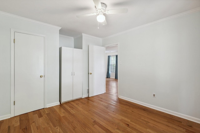1000 S Cox St, Memphis, TN 38104 - unfurnished bedroom featuring wood finished floors, crown molding, baseboards, and a ceiling fan