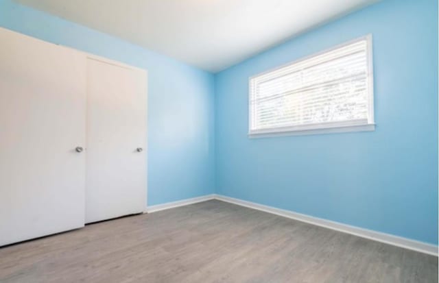12580 Macon Rd, Tn, TN 38017 - unfurnished bedroom with wood finished floors, a closet, and baseboards