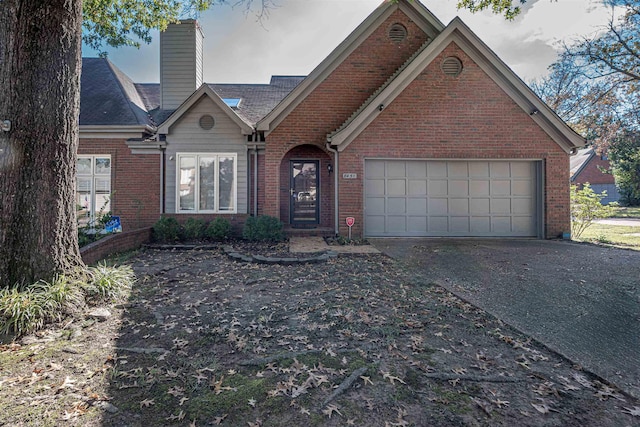 8451 Donegal Cv, Germantown, TN 38139 - view of front of house with brick siding, driveway, a chimney, and a garage