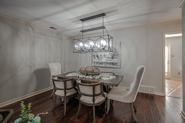 8451 Donegal Cv, Germantown, TN 38139 - dining area featuring ornamental molding, dark wood-type flooring, baseboards, a textured ceiling, and a chandelier