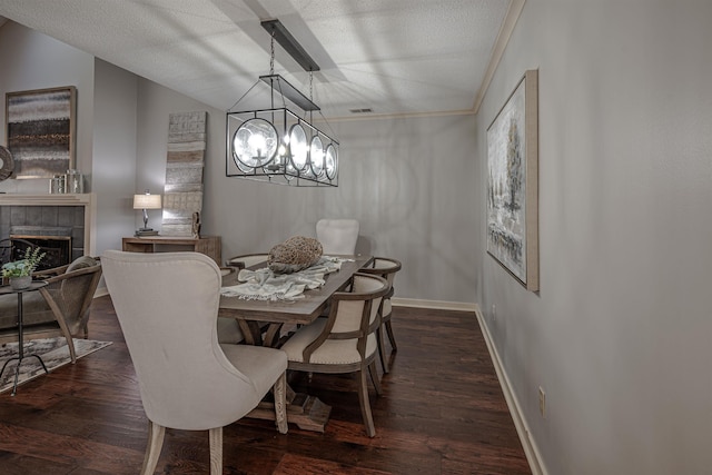 8451 Donegal Cv, Germantown, TN 38139 - dining space with a fireplace, a chandelier, baseboards, ornamental molding, and dark wood-type flooring