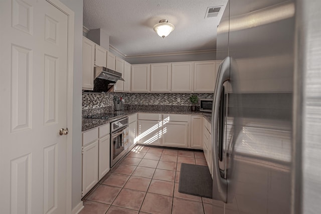 8451 Donegal Cv, Germantown, TN 38139 - kitchen with stainless steel appliances, backsplash, light tile patterned flooring, white cabinets, and a textured ceiling