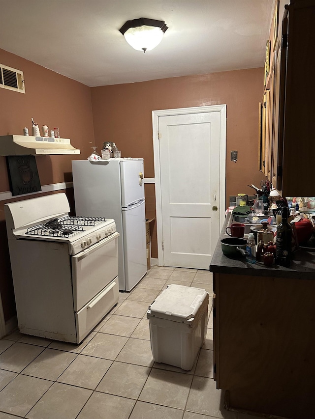 1503 Hope St, Memphis, TN 38111 - kitchen featuring white appliances, light tile patterned floors, under cabinet range hood, and dark countertops