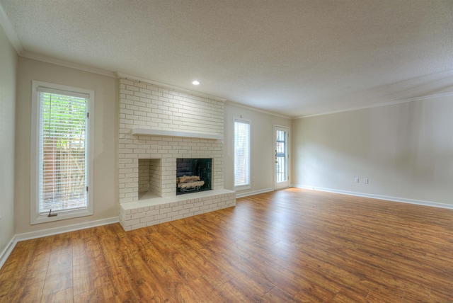 1823 Allenby Green Dr Unit 6, Germantown, TN 38139 - unfurnished living room featuring a textured ceiling, wood finished floors, crown molding, baseboards, and a brick fireplace