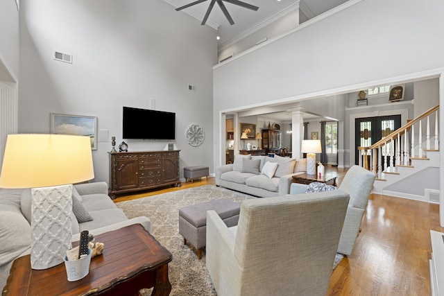 9245 Forest Estates Cv, Germantown, TN 38139 - living area featuring ceiling fan, ornate columns, wood finished floors, a high ceiling, and ornamental molding